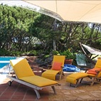 Zona piscina attrezzata con ombrellone, sdraio e tavolo